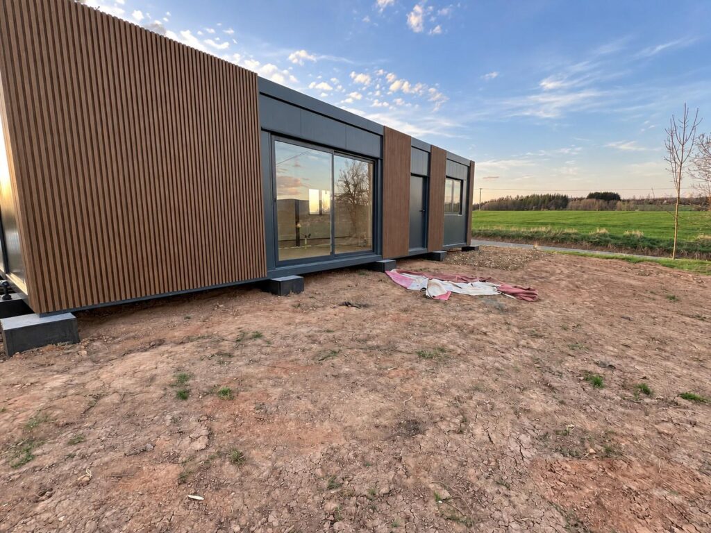 Modul Marie 72 m² z podhledu, tmavá fasáda a svislý obklad